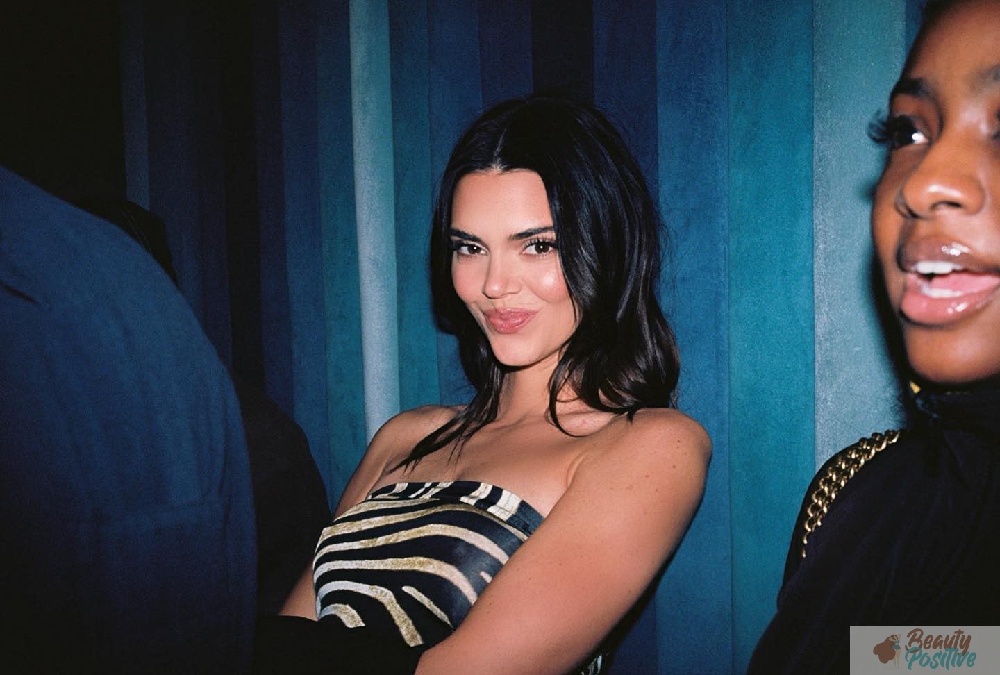 Kendall Jenner in a strapless zebra-print top at a party, photographed on film