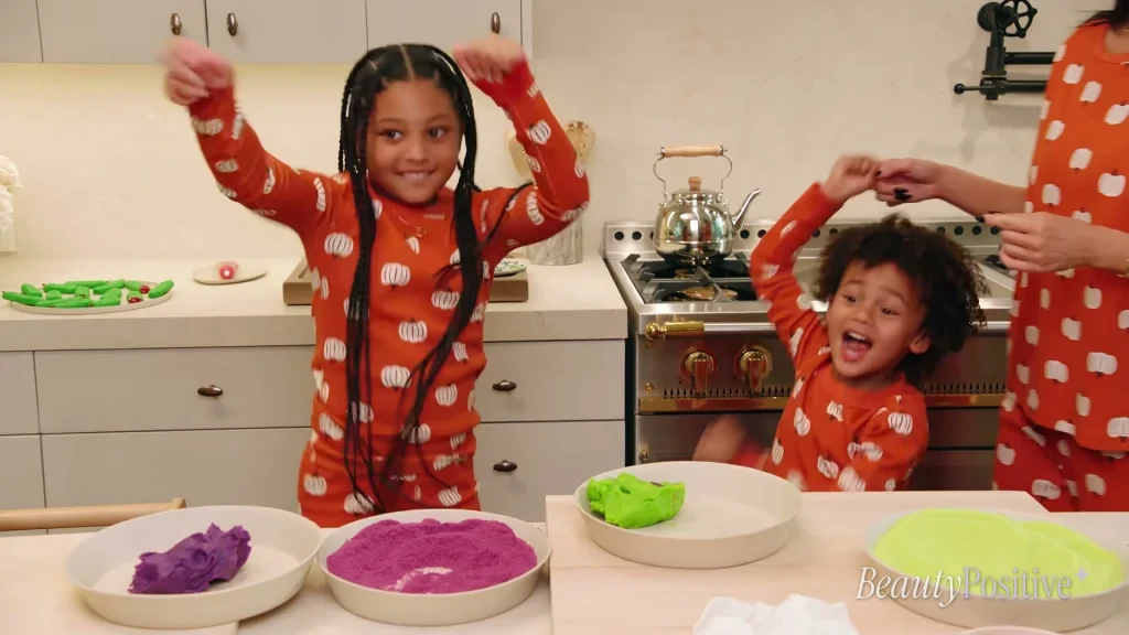 Stormi and Aire cheering at the kitchen counter with Kylie